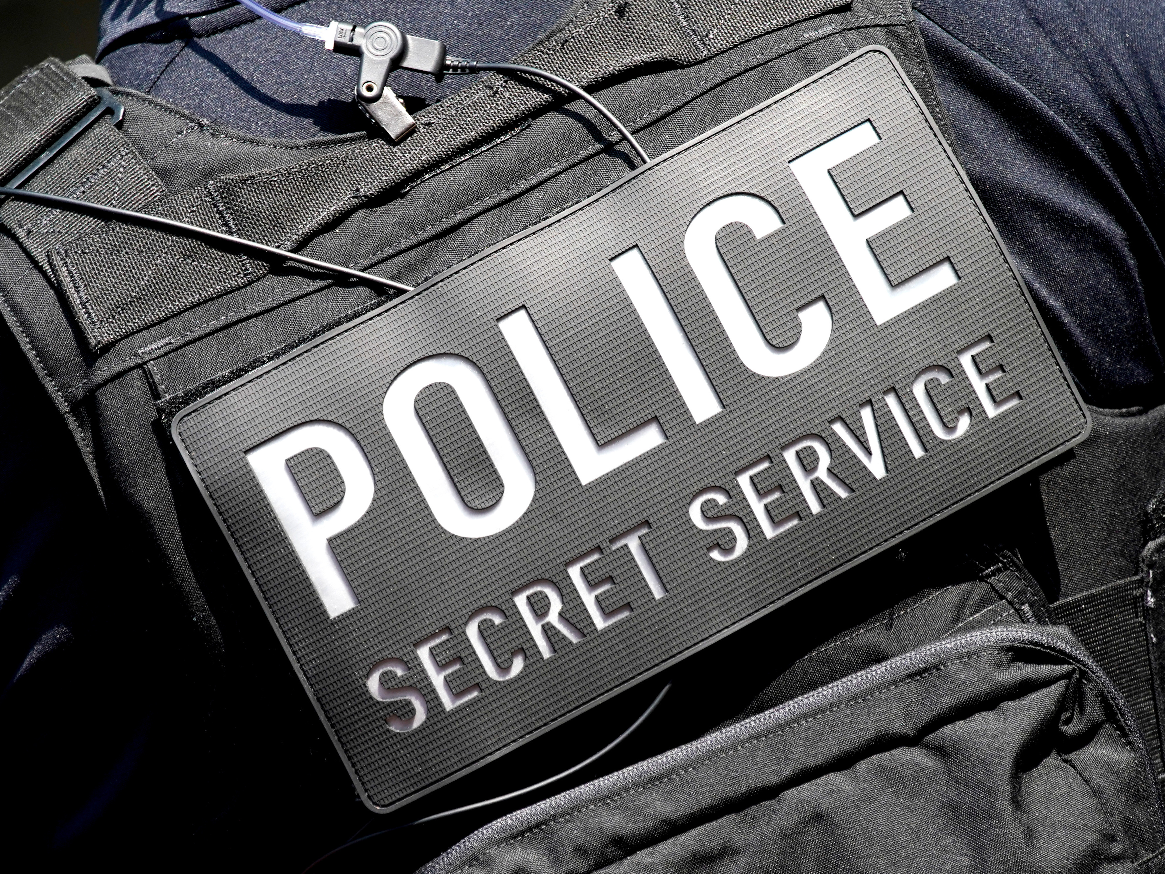 A closeup of a secret service vest
