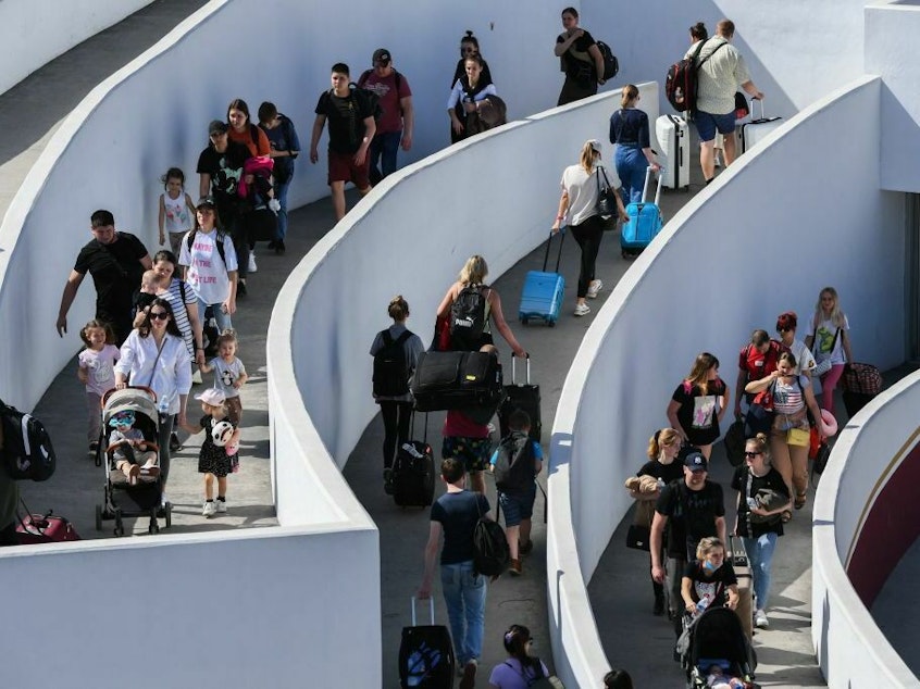 caption: Ukrainian refugees enter the El Chaparral border crossing between Tijuana, Mexico, and San Diego in April 2022. The foreign-born share of the U.S. population, which had been roughly flat since 2017, rose to nearly 14% last year.