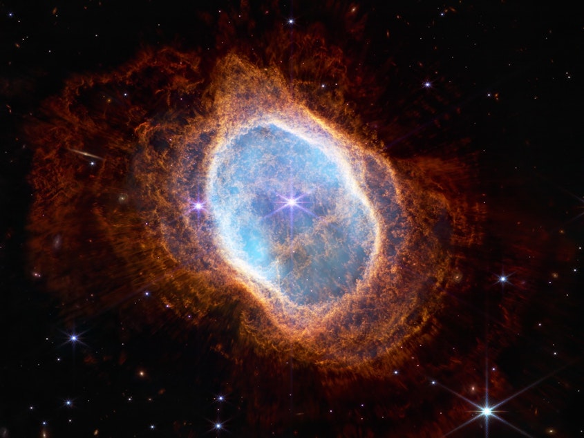 caption: The bright star at the center of NGC 3132, Southern Nebula Ring, while prominent when viewed by NASA's Webb Telescope in near-infrared light, plays a supporting role in sculpting the surrounding nebula. A second star, barely visible at lower left along one of the bright star's diffraction spikes, is the nebula's source. It has ejected at least eight layers of gas and dust over thousands of years.