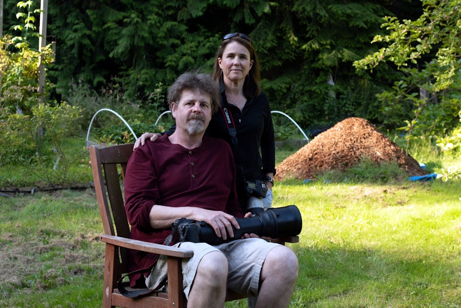 caption: Michelle and Dave Grimmer in their backyard on Marrowstone Island, Washington. They started the Facebook group Pacific Northwest Birding. 