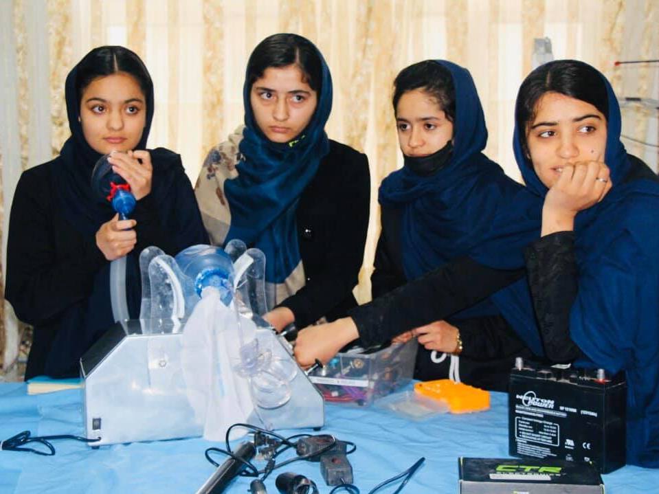 caption: Elham Mansori, Florence Poya, Nahida Khajazadeh and Somaya Farooqi, members of the Afghan Dreamers, are building a mechanized version of the hand-operated ventilator.