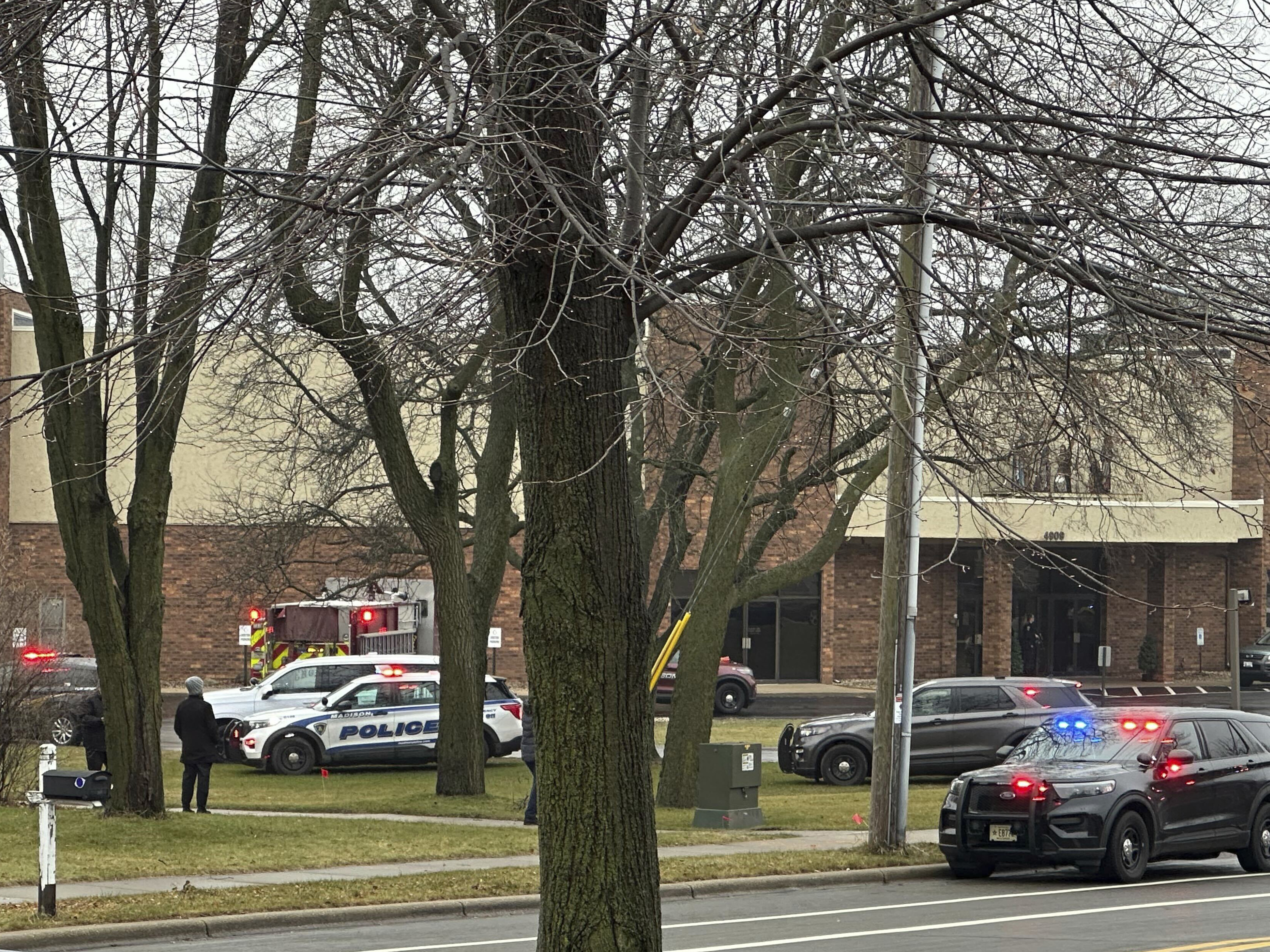 caption: Emergency vehicles are parked outside the Abundant Life Christian School in Madison, Wis., where multiple injuries were reported following a shooting, Monday.