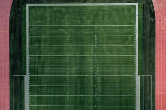 caption: An aerial view of an empty football field at Towson University in Towson, Md. Many colleges rely on summer camps for additional revenue during the summer.