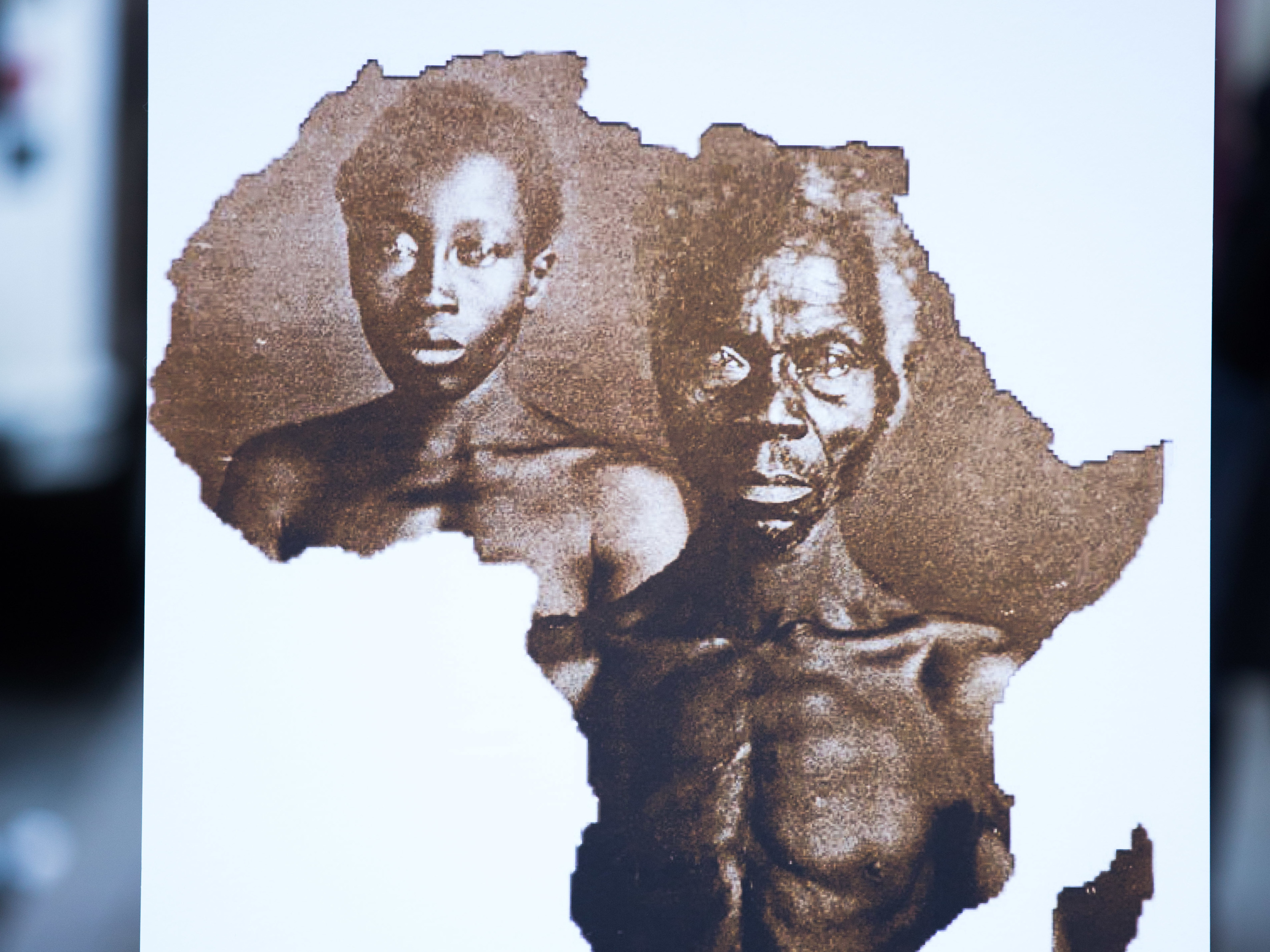 caption: A sample image of "Papa" Renty and his daughter Delia, taken in 1850, are displayed during a press conference announcing a lawsuit against Harvard University on Wednesday in New York City.