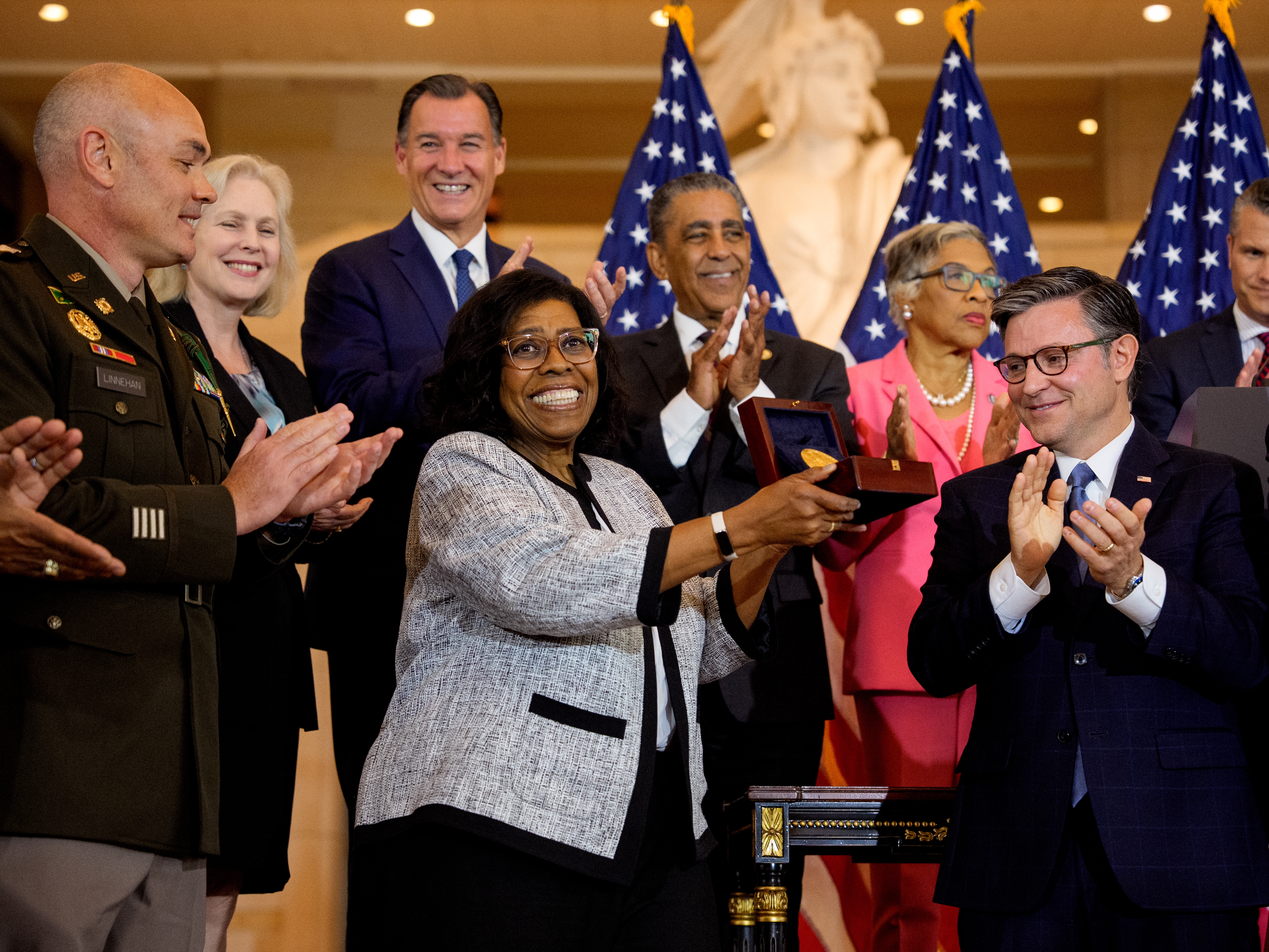 caption: House Speaker Mike Johnson, R-La., presents Debra Willett, the granddaughter of Harlem Hellfighter Sgt. Leander Willett, with the Congressional Gold Medal on behalf of all of the "Harlem Hellfighters" of World War I during a ceremony on Capitol Hill on Wednesday in Washington, D.C.