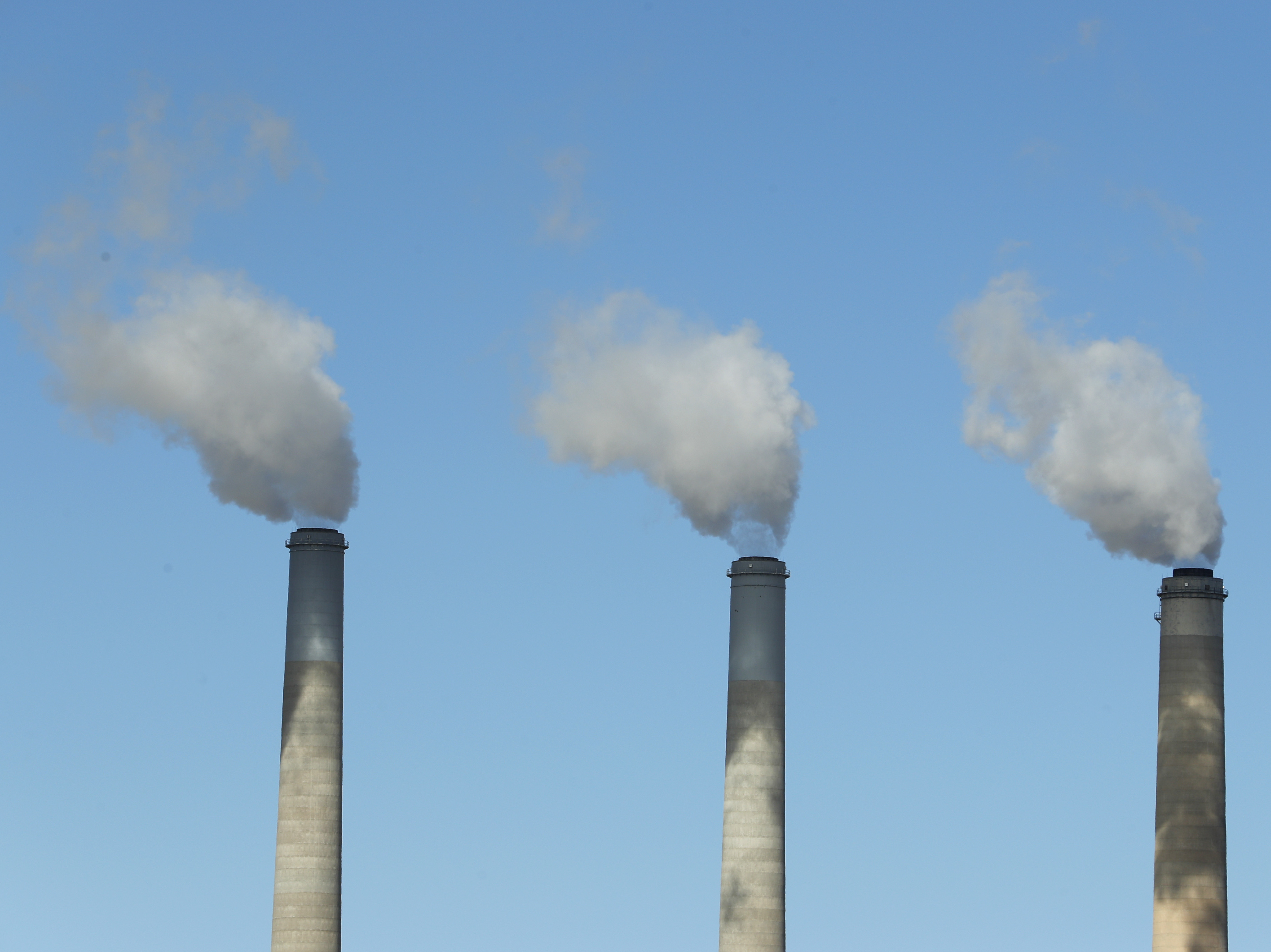 caption: Emissions rise from three large smokestacks at a coal-fired power plant in Castle Dale, Utah, in 2017. Democratic presidential candidates are releasing plans to reduce U.S. emissions in order to head off the most dangerous consequences of global warming.