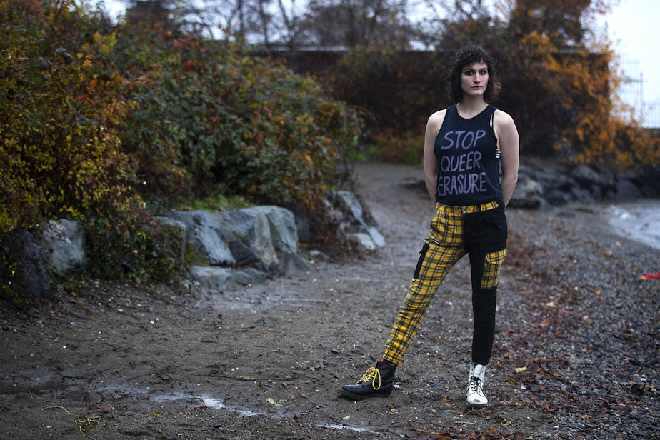 caption: Sophie Amity Debs, 25, is portrayed while wearing a shirt that reads 'stop queer erasure' at Denny Blaine Park on Tuesday, Dec. 5, 2023, in Seattle. 