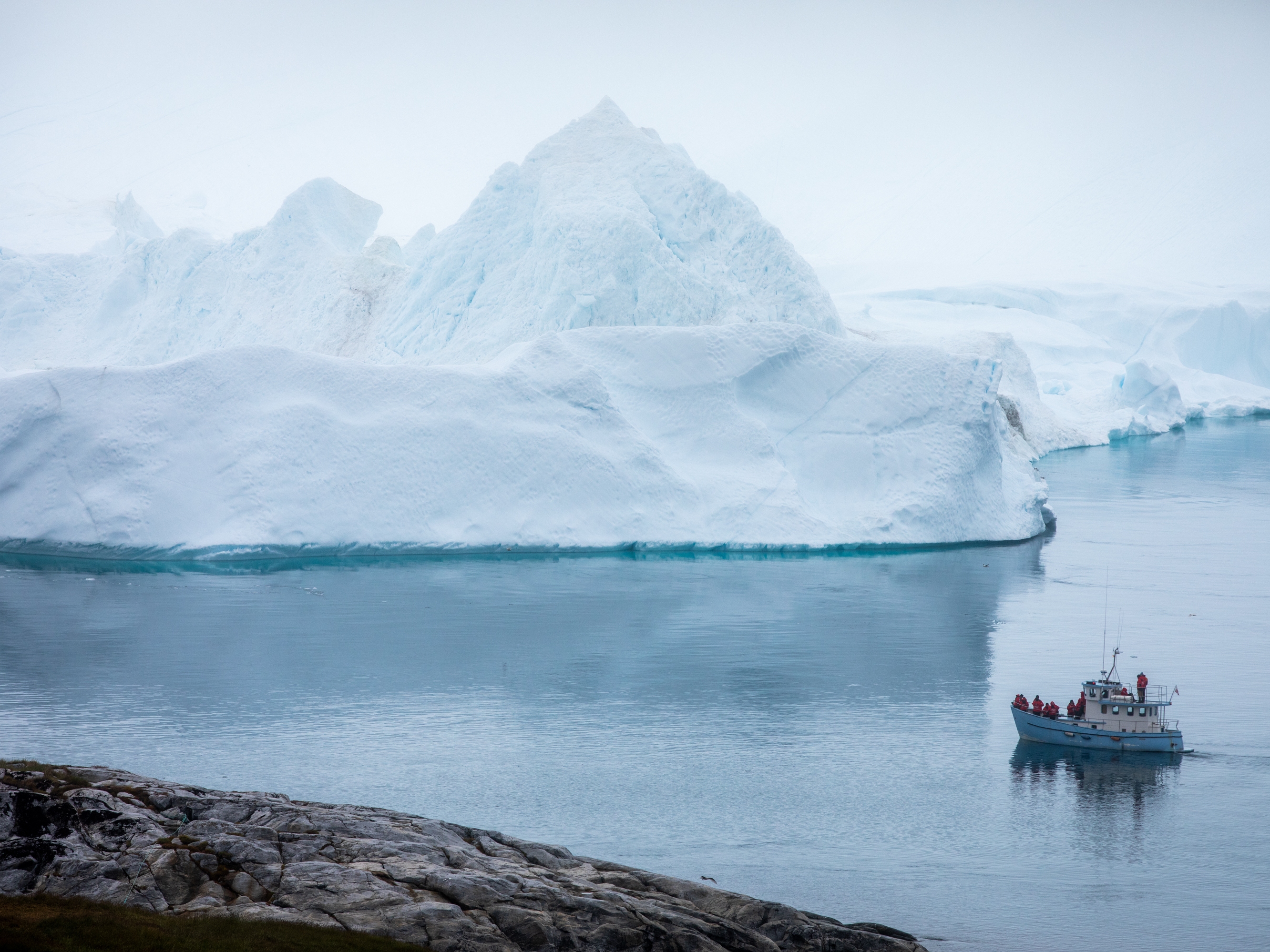 caption: An iceberg in Ilulissat, Greenland. Ice sheets in Greenland and Antarctica are melting rapidly, and that melt will accelerate as the Earth heats up.