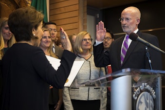 caption: Councilmember Tim Burgess, right, takes the oath of office, administered by Seattle City Clerk Monica Simmons, on Monday, September 18, 2017, becoming the mayor of Seattle, at City Hall in Seattle. 