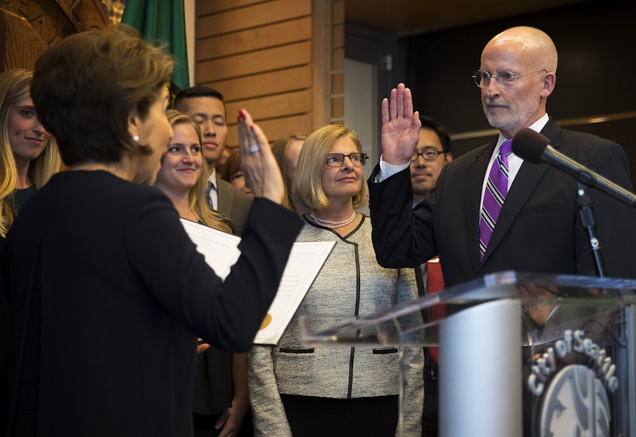 caption: Councilmember Tim Burgess, right, takes the oath of office, administered by Seattle City Clerk Monica Simmons, on Monday, September 18, 2017, becoming the mayor of Seattle, at City Hall in Seattle.
