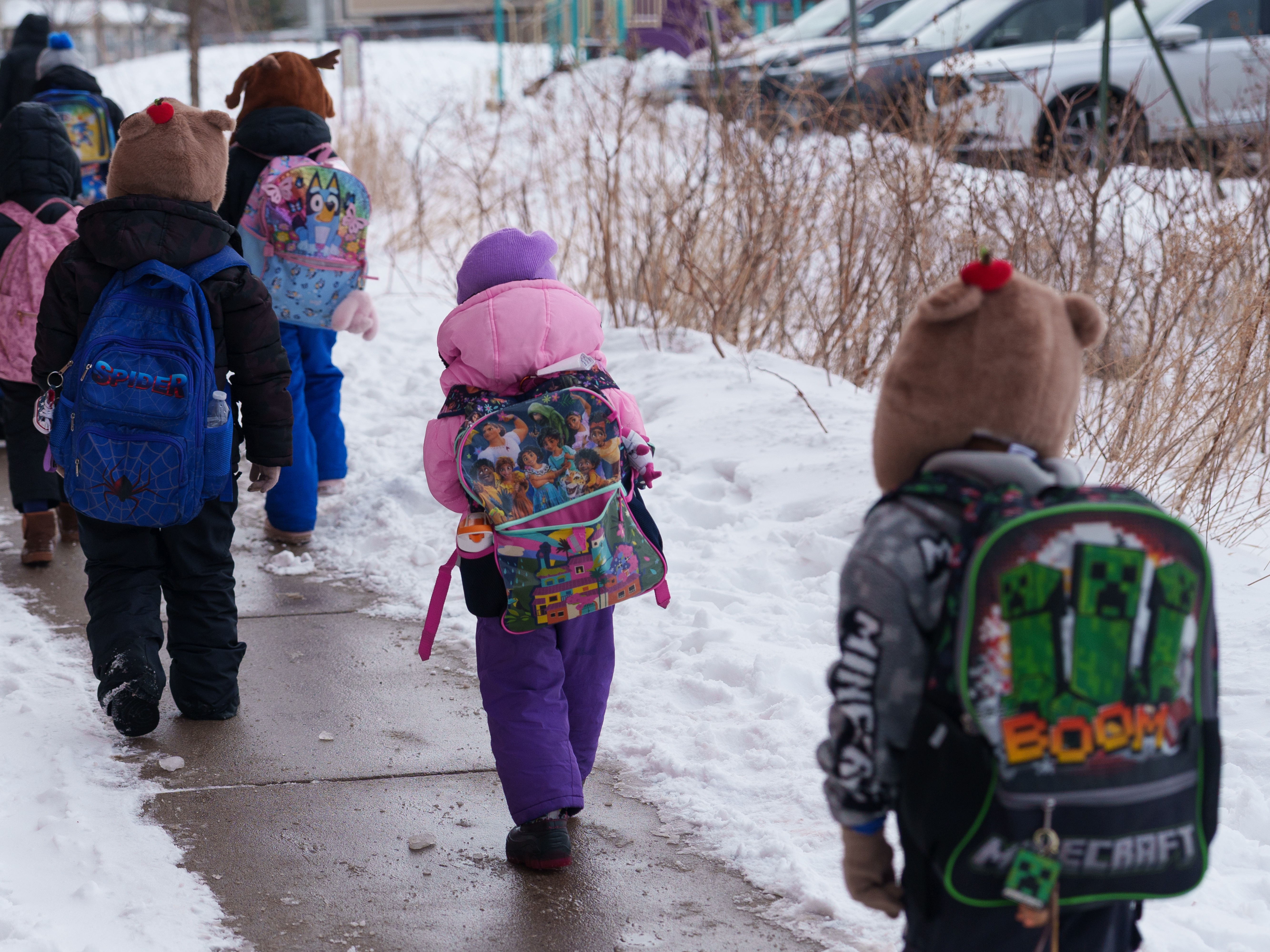 caption: Students walk from the bus to their elementary school in St. Paul, Minn., on March 18. For many students, it was the first week back after nearly two months of online learning.