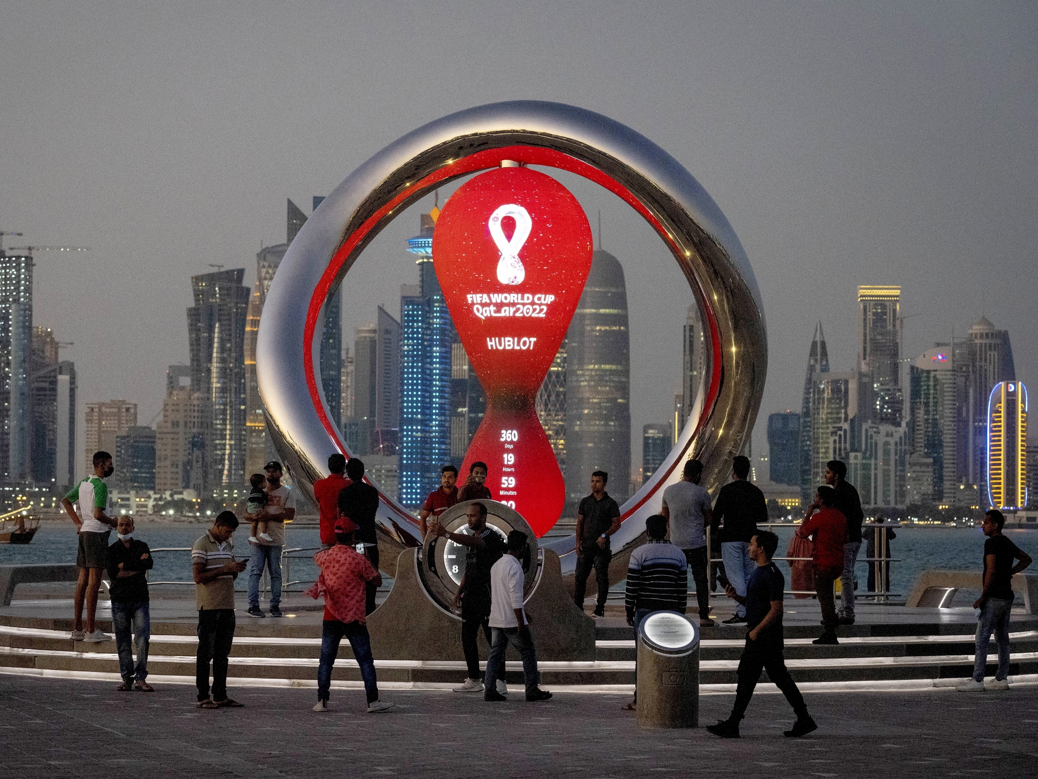 caption: People gather in November 2021 around the official countdown clock showing remaining time until the kick-off of the World Cup 2022 in Doha, Qatar.