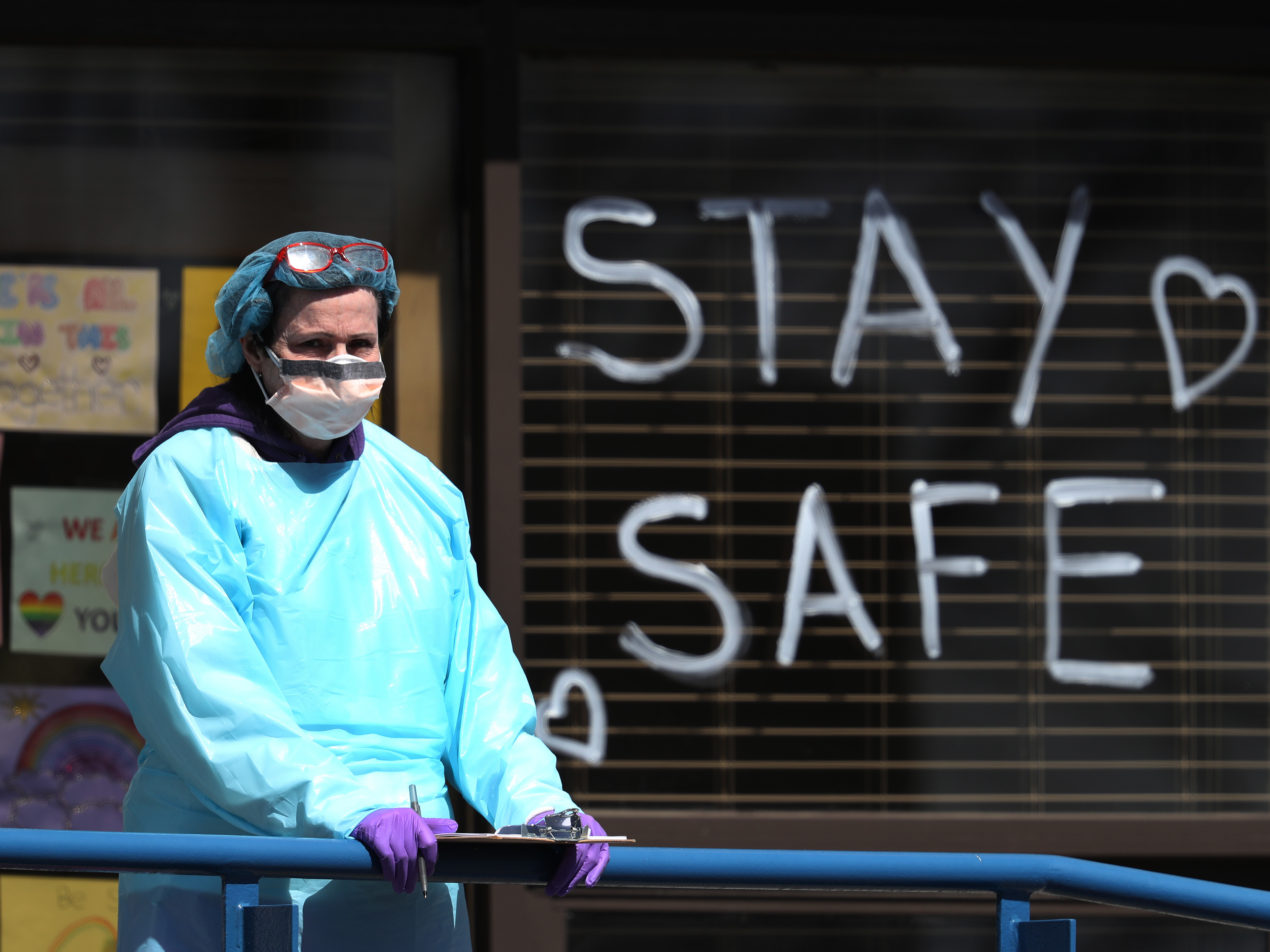caption: A health care worker staffs a drive-thru coronavirus testing site in Jericho, N.Y., a state that remains the hardest-hit by the COVID-19 pandemic. The disease has killed more than 10,000 people in the U.S., and 4,758 in New York.