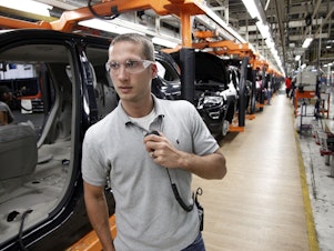 caption: In this Wednesday, May 8, 2013 photo, Jeff Caldwell, 29, a chassis assembly line supervisor, monitors the assembly line at the Chrysler Jefferson North Assembly plant in Detroit.