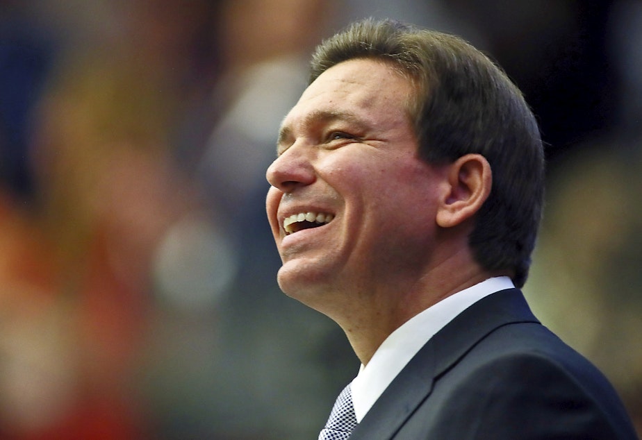 caption: Florida Gov. Ron DeSantis smiles as he ends his State of the State address during a joint session of the Senate and House of Representatives on March 7in Tallahassee, Fla.