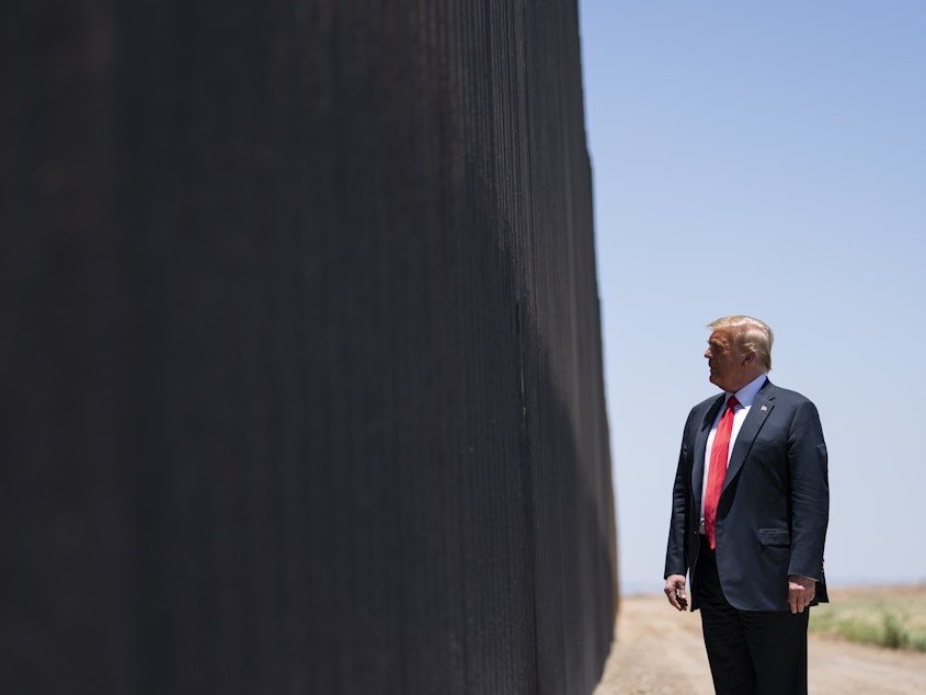 caption: President Trump tours a section of the border wall in San Luis, Ariz., on June 23. The Supreme Court is agreeing to review a Trump administration policy that makes asylum-seekers wait in Mexico for U.S. court hearings.