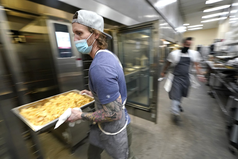 caption: evin Benner, a chef at The Lakehouse, a restaurant located in Bellevue, Wash., carries a tray of potato cakes as he works in the kitchen at Lumen Field, Thursday, Feb. 18, 2021, in Seattle. Benner was one of the chefs taking part in the inaugural night of the "Field To Table" event at stadium, which is home to the Seattle Seahawks NFL football team. 