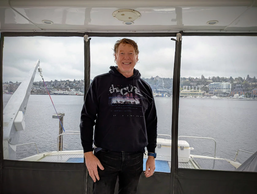 caption: Greg Holloway gives a tour of the luxury yacht he owns and charters out to customers with Seattle's Lake Union in the background.