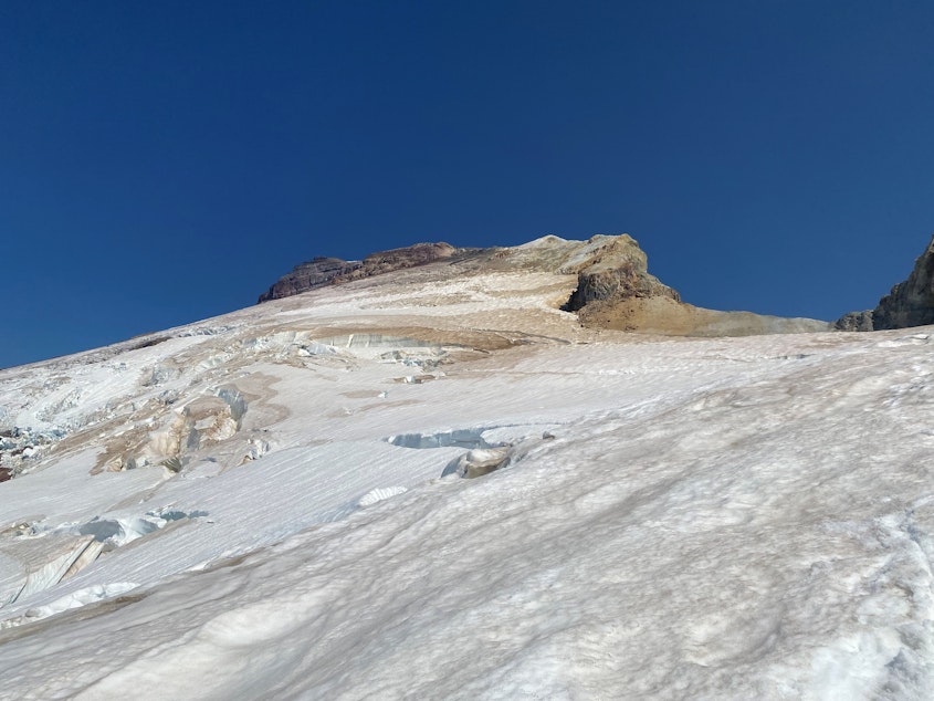 caption: Bare brown rock juts out above Mount Baker's Easton Glacier on Aug. 28, 2023.
