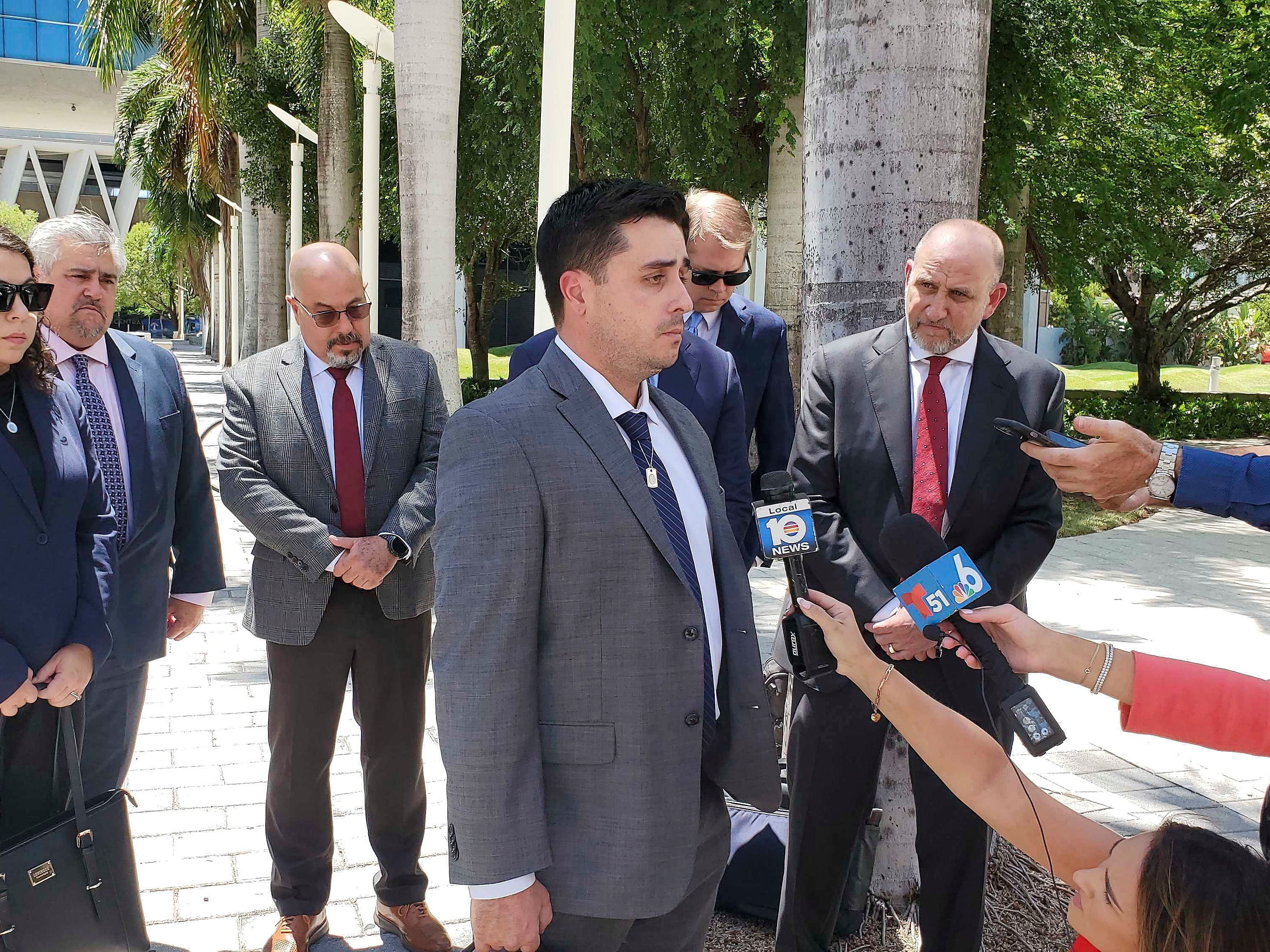 caption: Dillon Angulo, who was seriously injured in a Florida crash involving Tesla's Autopilot driver assist technology, speaks to reporters outside the federal courthouse in Miami on Friday.