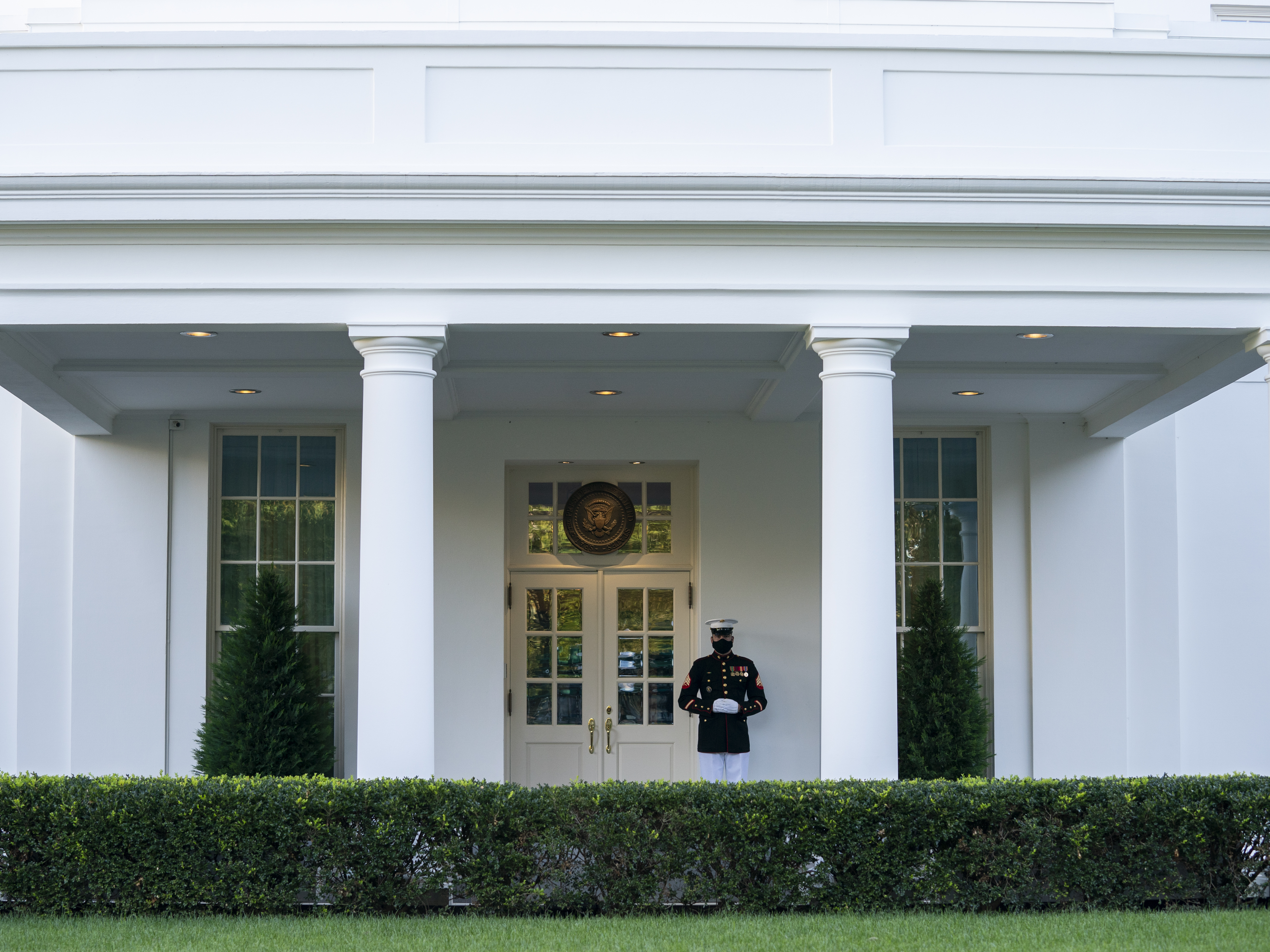 caption: A Marine is posted Thursday outside the West Wing of the White House, signifying the president is in the Oval Office. President Trump's physician said that he could return to public engagements as soon as Saturday.