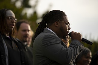 caption: Pastor James E. Sears III speaks to a crowd at Garfield High School on Thursday, June 13, 2024, during a unity walk in honor of Amarr Murphy Paine, a 17-year-old Garfield high school student that was shot and killed at school, in Seattle. 