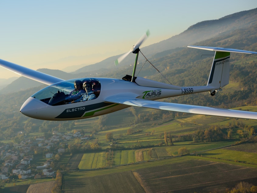 caption: A Pipistrel Taurus Electro electric two-seat airplane flies above Ajdovscina, Slovenia.