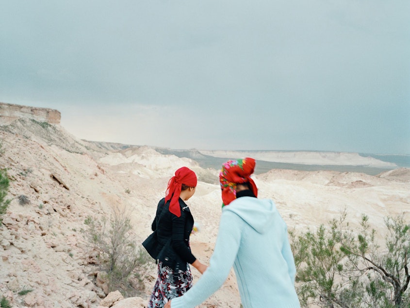 caption: Two sisters run down to the remote underground mosque at Beket-Ata. They traveled six hours from Aktau, accompanying their family on a pilgrimage to pray for their uncle's recovery. Mangystau Region, Kazakhstan, 2010.