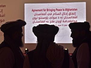 caption: Members of the Taliban delegation gather ahead of Saturday's signing ceremony with the United States in the Qatari capital of Doha.