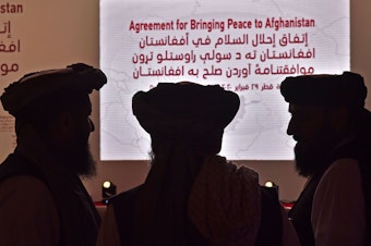 caption: Members of the Taliban delegation gather ahead of Saturday's signing ceremony with the United States in the Qatari capital of Doha.