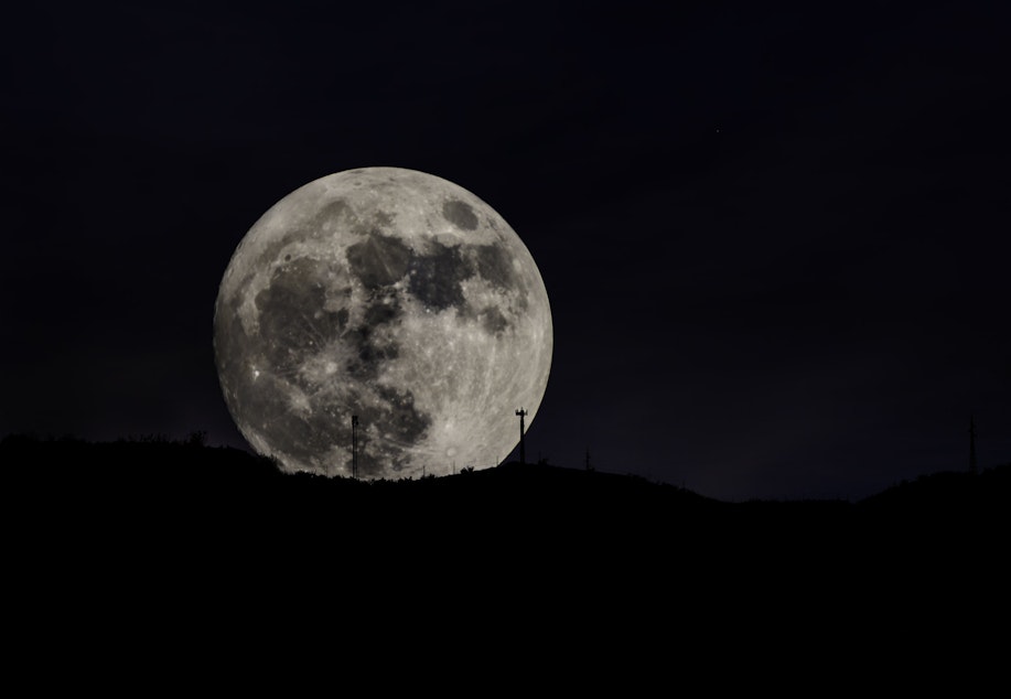 caption: The super moon, as seen rising over the Sierra Nevada mountains, Southern Spain.