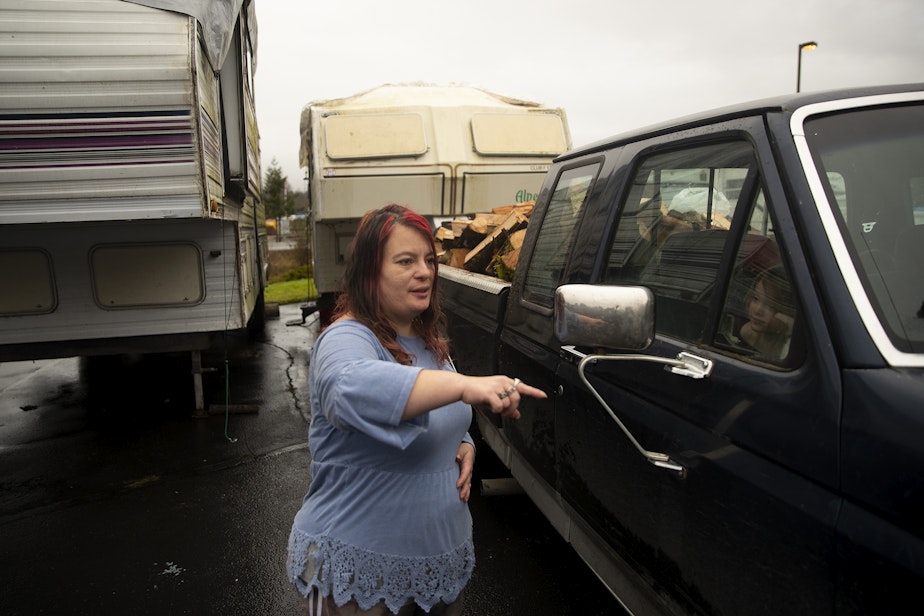 caption: Alisha Stevens of Hamilton talks with a friend while sheltering in an RV at the Red Cross shelter on Wednesday, December 6, 2023, set up at the Hamilton First Baptist Church. 