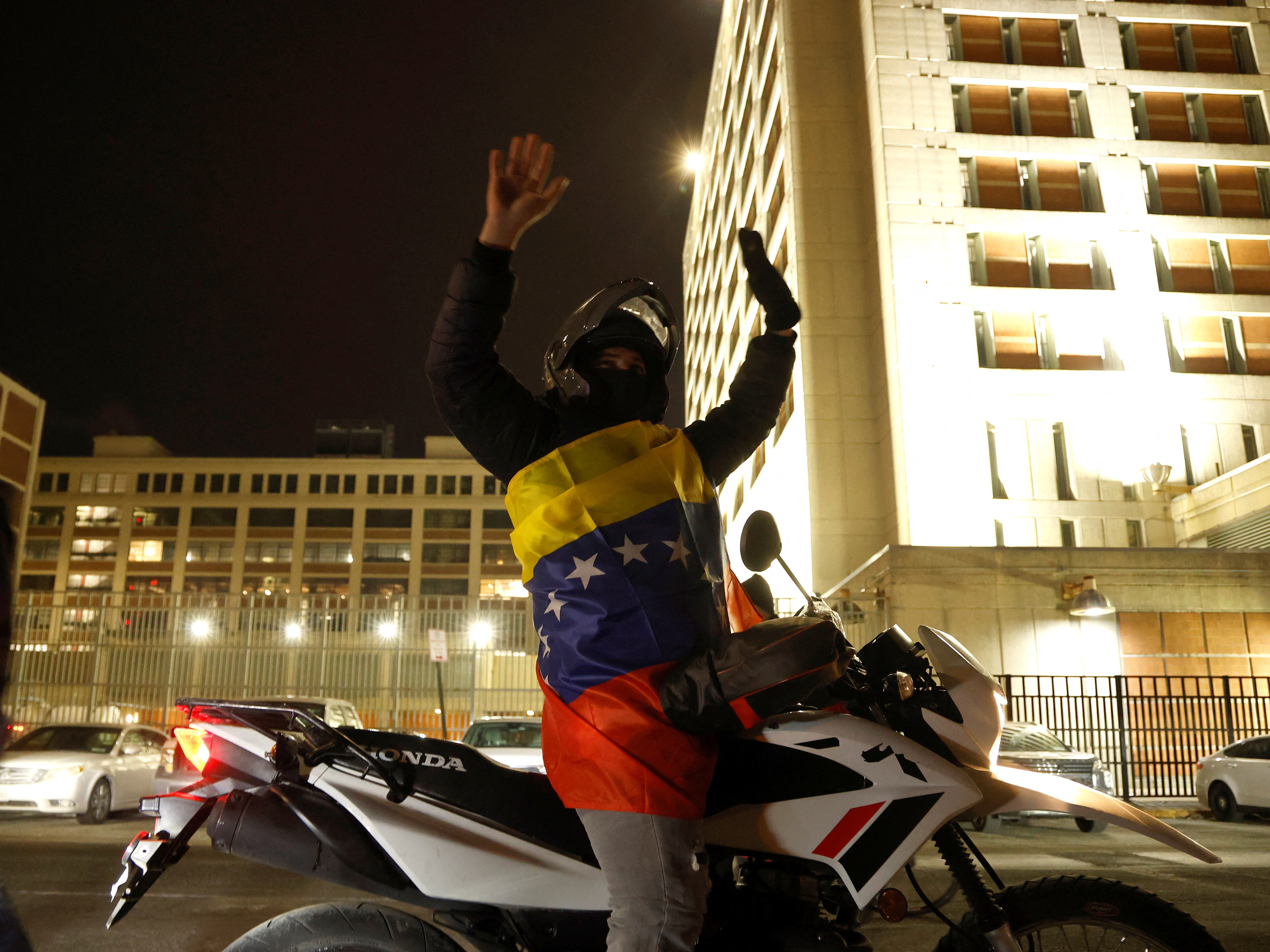 caption: A Venezuelan supporter of U.S. operations in Venezuela celebrates in front of the Metropolitan Detention Center in Brooklyn on Saturday.