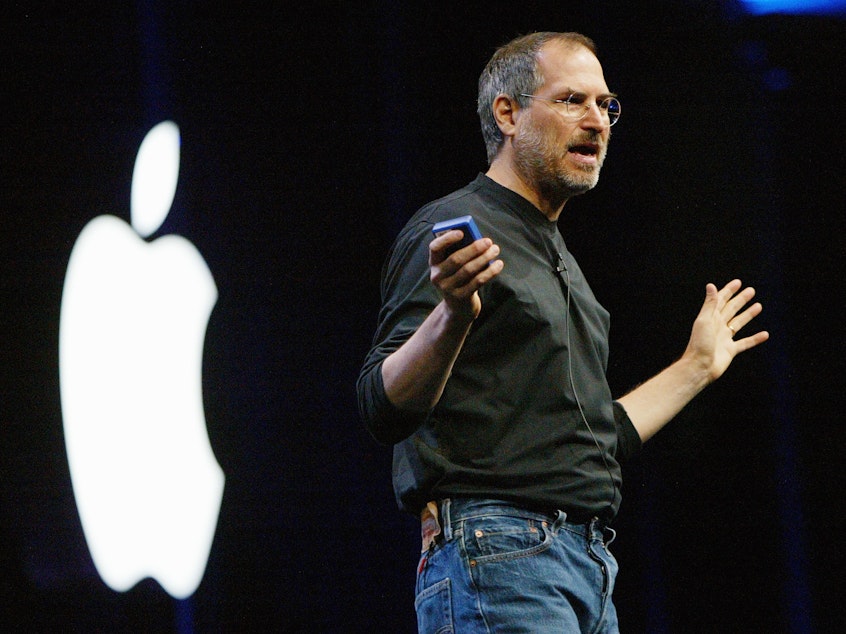 caption: Steve Jobs, then CEO of Apple, delivers the keynote address at the Worldwide Developers Conference in 2003 in San Francisco. Jobs created a personal uniform for himself that featured a black turtleneck from Japanese designer Issey Miyake.