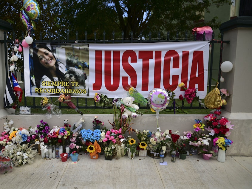caption: Flowers, balloons and a poster with the Spanish word for "justice" is part of a growing makeshift memorial for Keishla Rodriguez whose lifeless body was found in a lagoon Saturday, at the entrance of where she lived in San Juan, Puerto Rico.