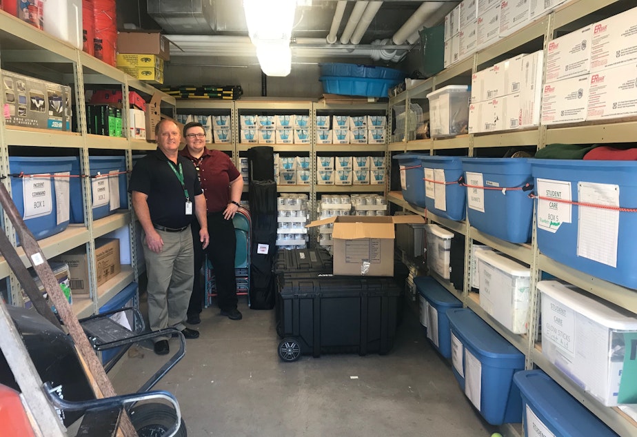caption: Bellevue School District Director of Security Doug James and Emergency Management Program Coordinator Ginger Bonnell show off the emergency supply cache at Sherwood Forest Elementary School on July 26, 2019.