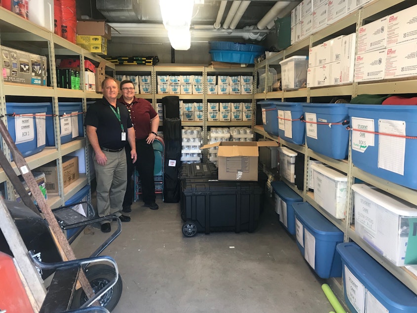 caption: Bellevue School District Director of Security Doug James and Emergency Management Program Coordinator Ginger Bonnell show off the emergency supply cache at Sherwood Forest Elementary School on July 26, 2019.