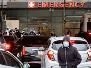 caption: People and cars line up outside Boston Medical Center near the emergency room, where COVID-19 testing was taking place, on Jan. 3.