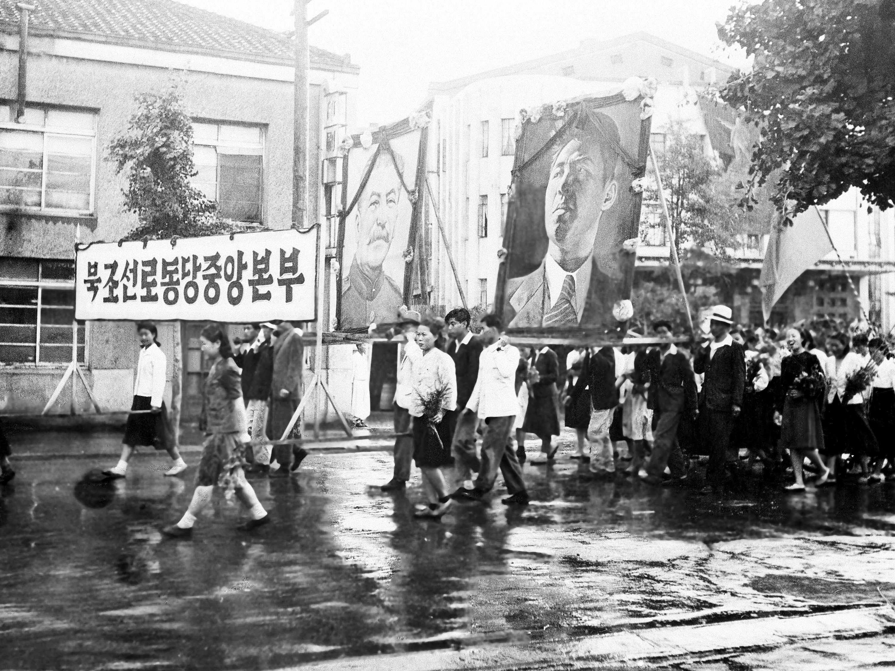 caption: Part of a welcome for the United States-Soviet commission on Korea on their arrival in Pyongyang on July 23, 1947, was this parade of Korean communists carrying huge portraits of Josef Stalin and Kim Il Sung. The commission visited Pyongyang, 165 miles north of Seoul, for the purpose of getting views of political groups on the prospecting.