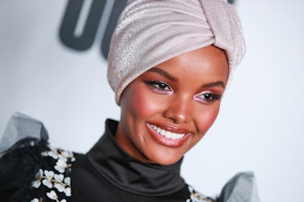 caption: Somali American and Muslim model Halima Aden wears a burkini for <em>Sports Illustrated</em>'s swimsuit issue, sparking both praise and critique on social media.