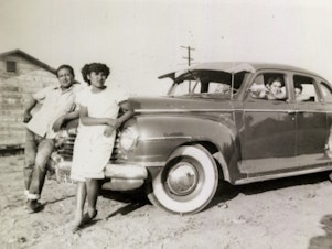 caption: Ricardo "Papu" Ovilla, left, and the family's first car. Ovilla is pictured with his children Martha (next to him) and Aurelia and Rodolfo Sandoval (left to right, inside the car) in a photo taken in 1949 at a labor camp in Escondido, Calif.