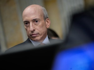 caption: The Securities and Exchange Commission, under Chair Gary Gensler, has approved several spot bitcoin exchange-traded funds, which will track the cryptocurrency's price.