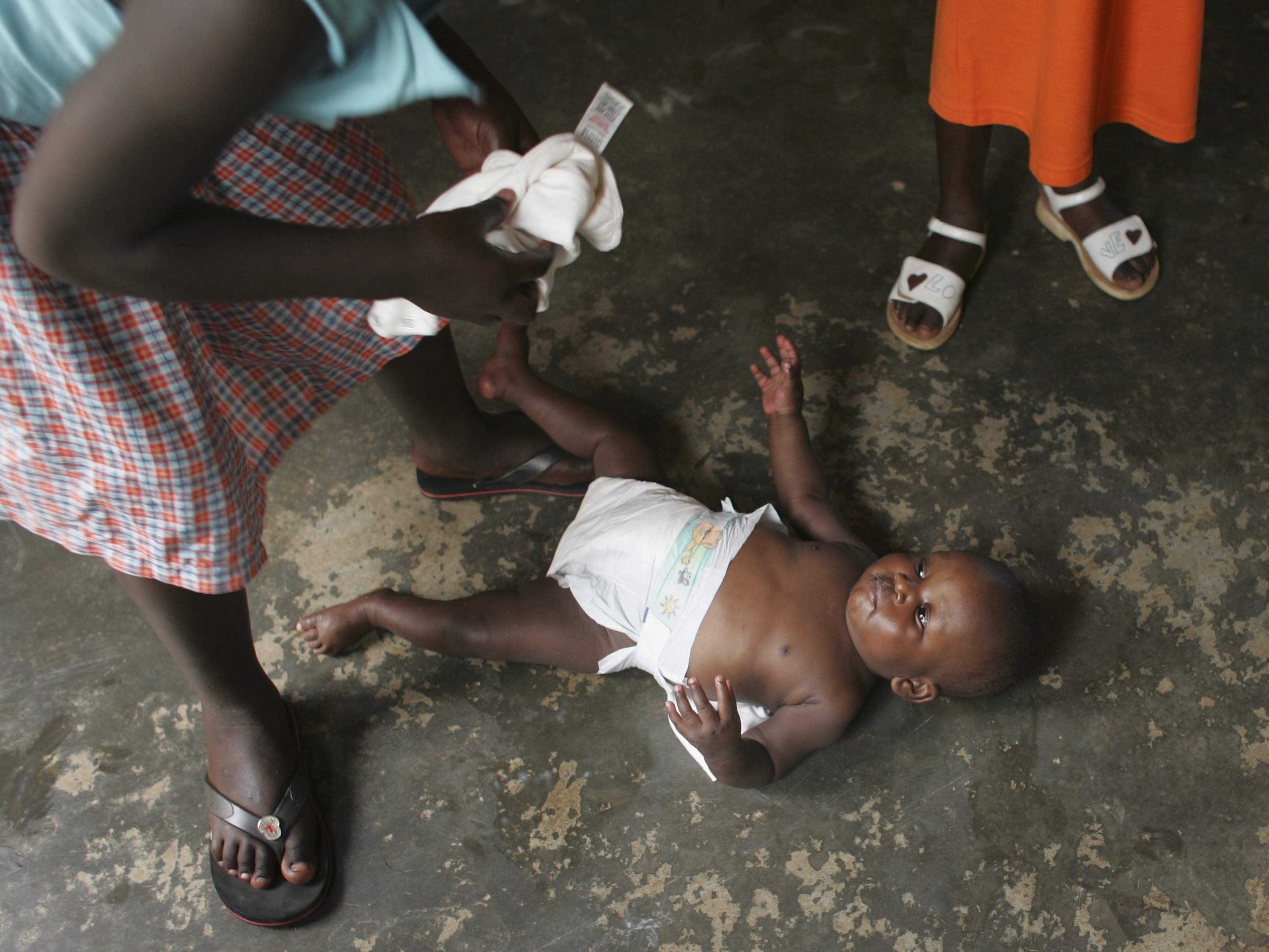 caption: A nurse changes an 18-month-old at a facility that cares for orphans living with AIDS who do not have the support of extended families.