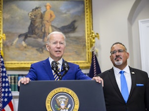 caption: President Biden speaks during a news conference with Miguel Cardona, U.S. secretary of education.