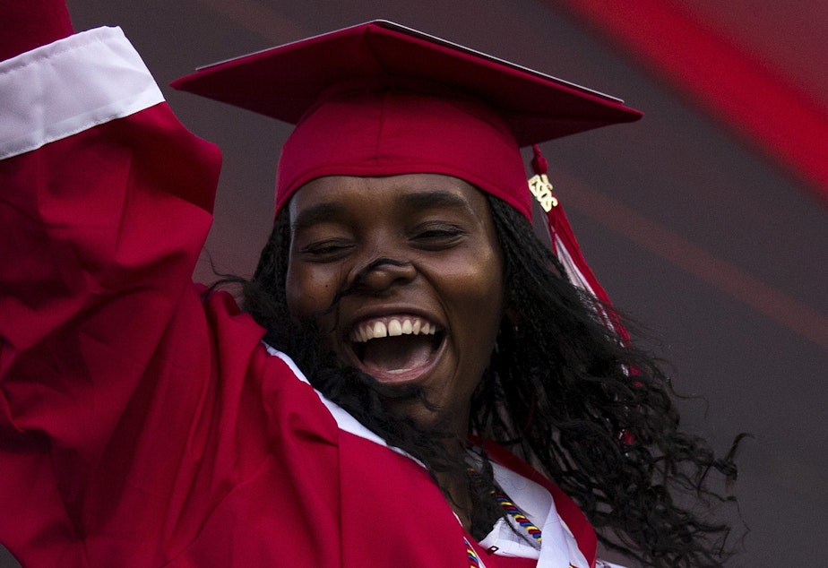 caption: Cleveland Stem High School senior Julia Nuñez Alvarez celebrates after picking up her diploma on Tuesday, June 15, 2021, during an in-person commencement ceremony at Memorial Stadium in Seattle.