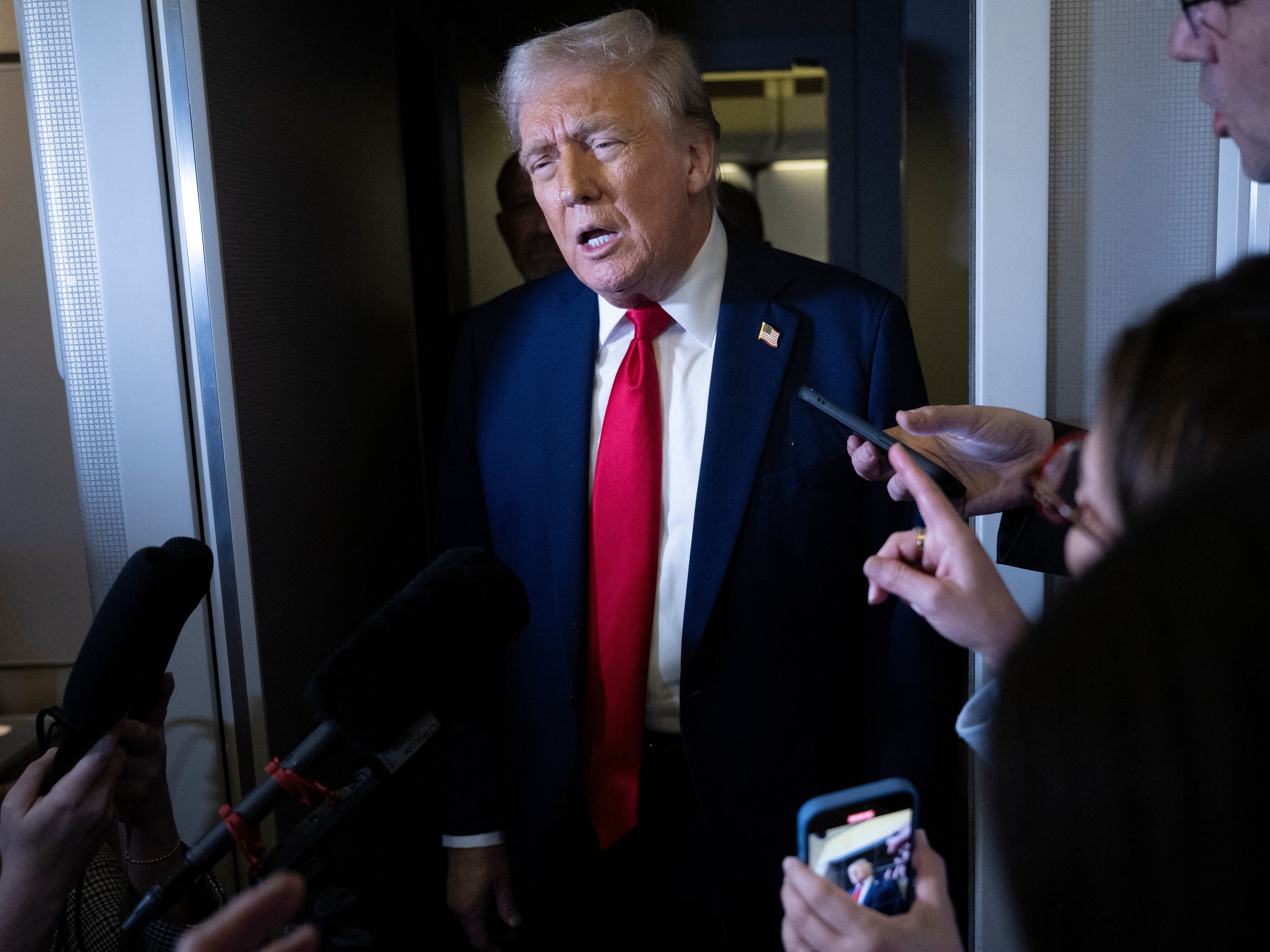 caption: President Trump speaks to members of the press aboard Air Force One on Sunday.