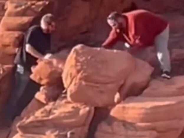 caption: An image provided by the National Park Service shows two men who were caught on video in April toppling rock formations at Lake Mead National Recreation Area. A federal jury has indicted Wyatt Clifford Fain, 37, and Payden David Guy Cosper, 31, of Henderson, Nev.