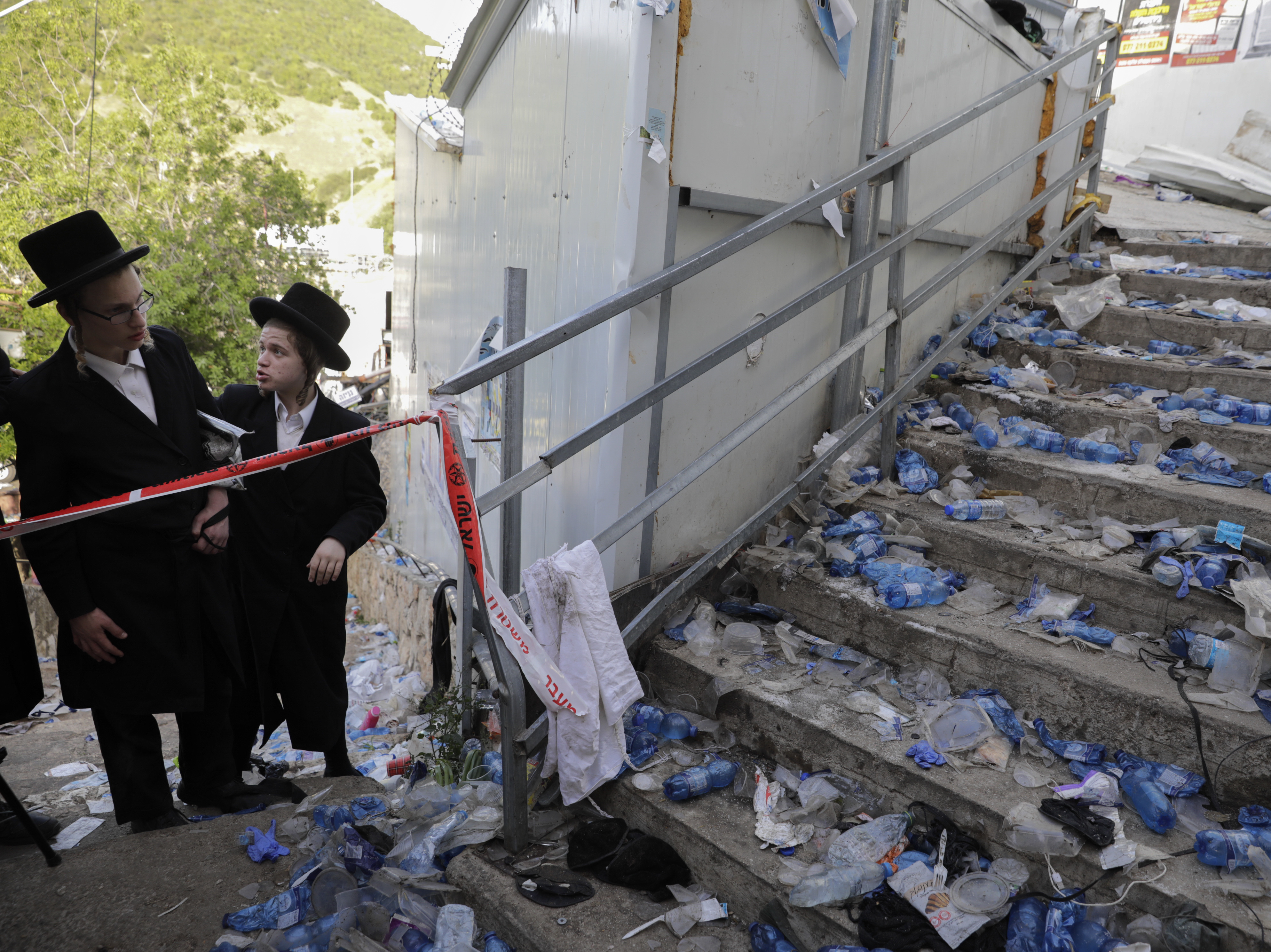 caption: Ultra Orthodox Jews look at the scene where dozens of people were killed and some 150 injured in a stampede during the Lag BaOmer festival at Mt. Meron in northern Israel on Friday.