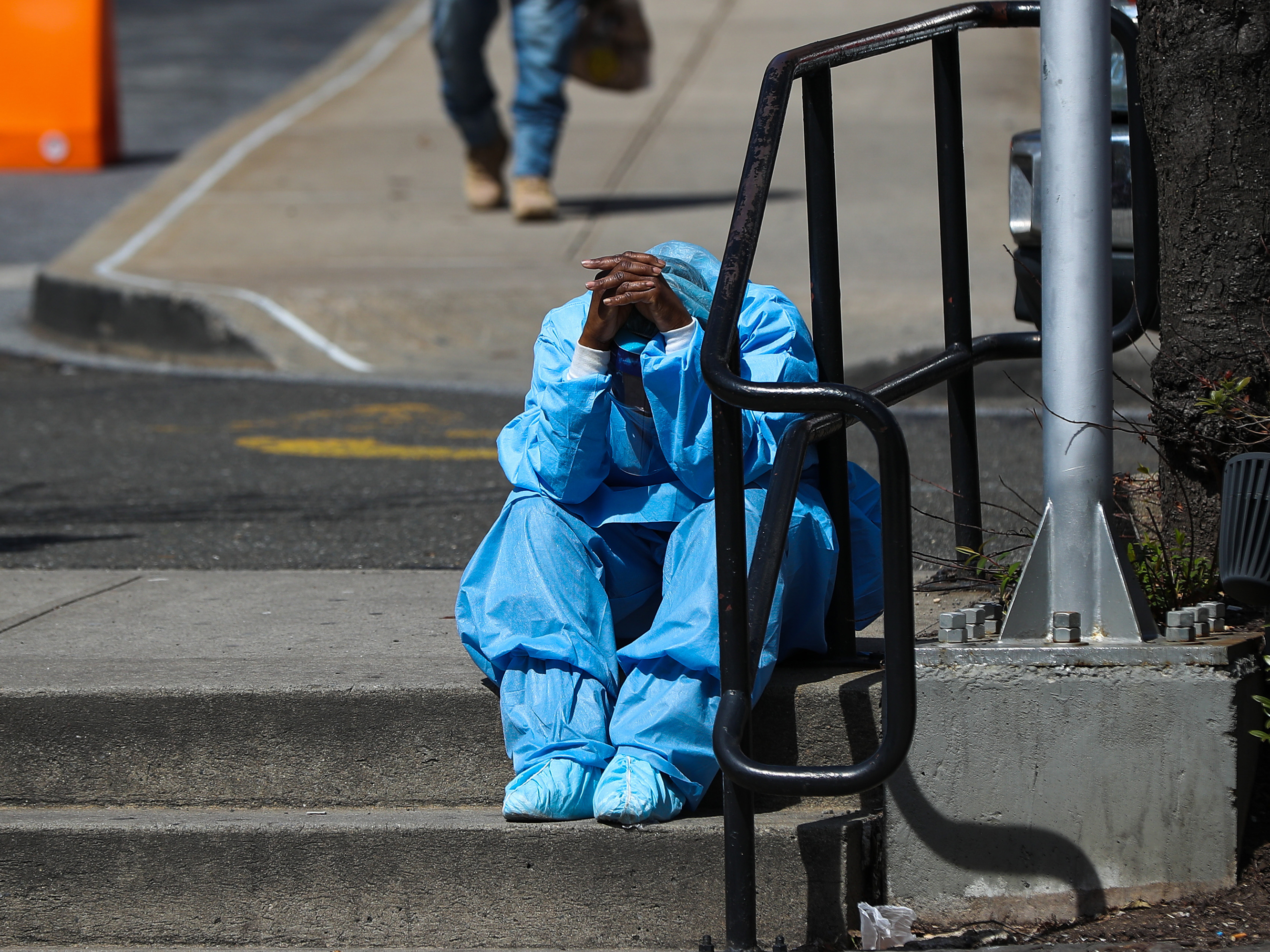 caption: A fatigued health care worker takes a moment outside the Brooklyn Hospital Center in April. Many hospital workers these days have to cope with horrific tragedies playing out multiple times on a single, 12-hour shift.
