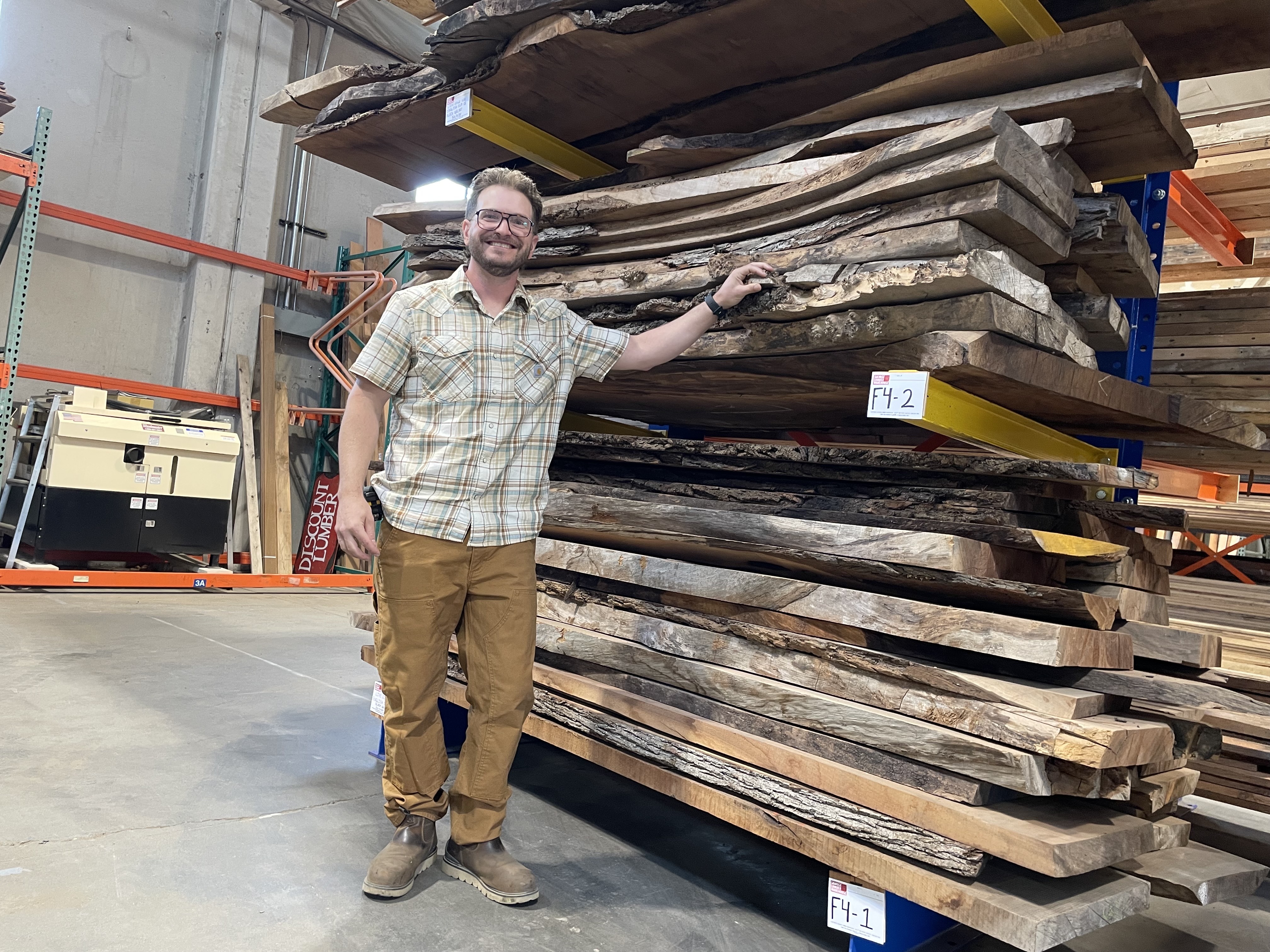 caption: Aaron Blanchard from Earthwise Architectural Salvage stands before a pile of salvaged black walnut and English elm boards in the company's new lumber salvage warehouse in Seattle's SoDo neighborhood. The warehouse is being funded by a $4 million grant from the EPA to the city of Seattle.